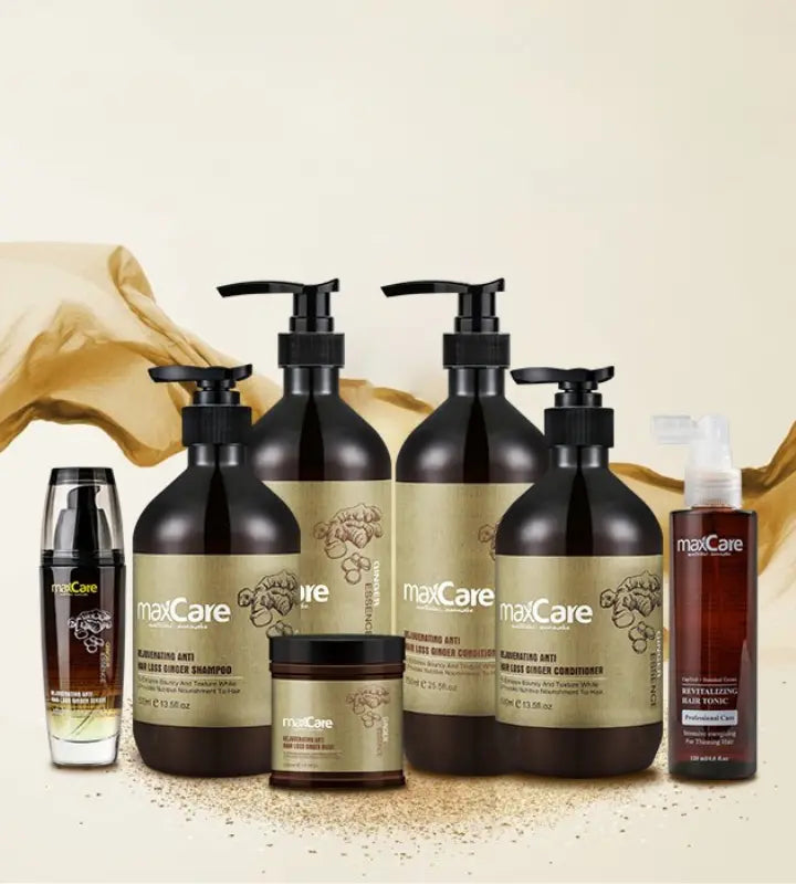 MaxCare Ginger hair care collection arranged with fresh ginger and green leaves. The set features rejuvenating anti-hair loss ginger shampoo, conditioner, hair mask, hair tonic, and scalp treatment foam, all in amber and gold packaging designed to promote scalp health and reduce hair thinning.